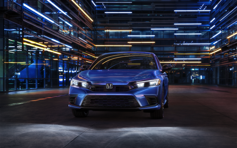 Honda Civic parked in front of a lit up building at night