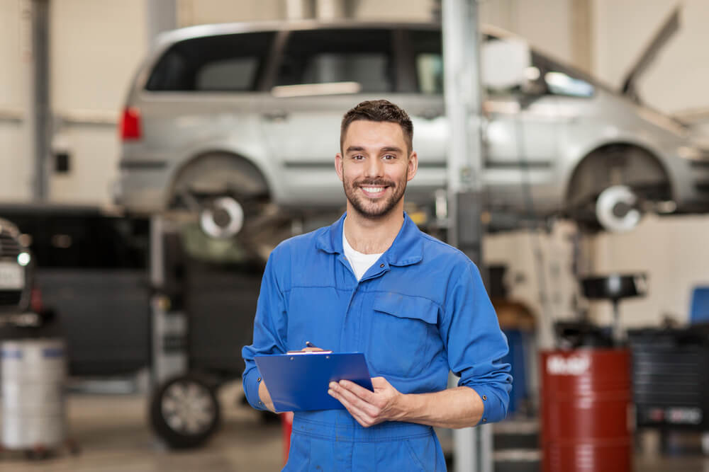 smiling mechanic in service bay