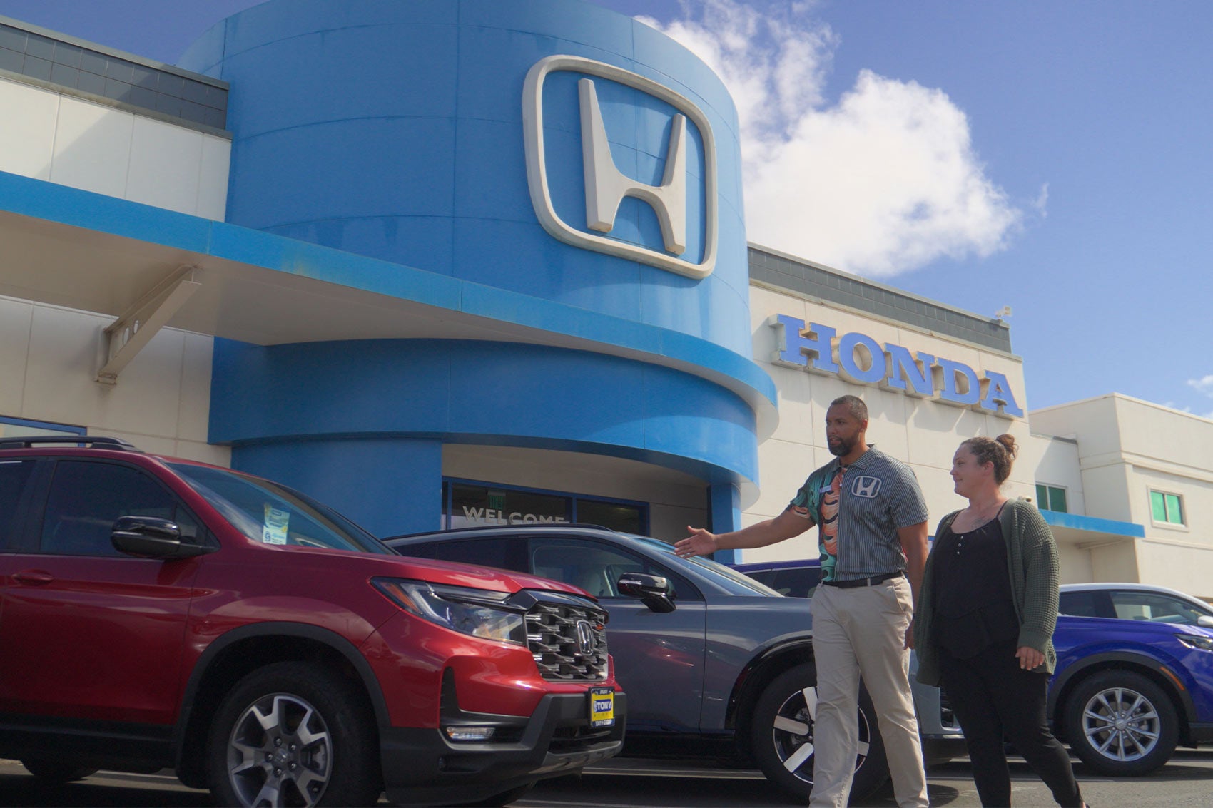 Owners unloading packages from Honda Prologue parked on side street